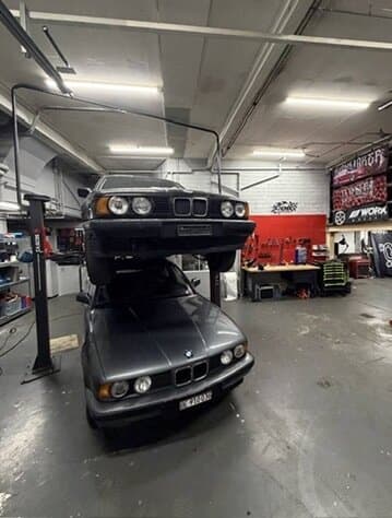 Zwei BMW E34 übereinander, einer auf der Hebebühne