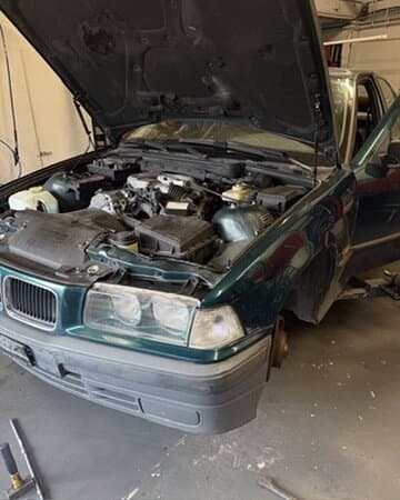 Offener Motorraum eines grünen BMW E36