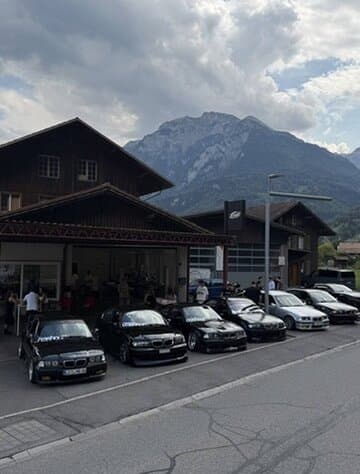 Eine Reihe BMW vor der COB Garage am Eröffnungstag, Berge im Hintergrund