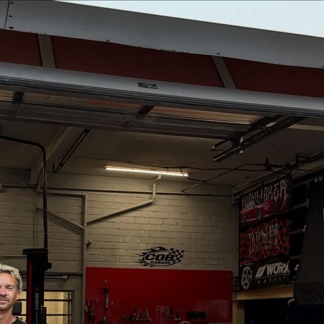Werkstatt der COB Garage von innen mit roter Wand und Hebebühne